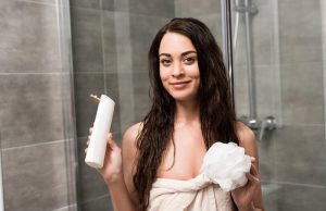 ΣΑΜΠΟΥΑΝ και ΑΦΡΟΛΟΥΤΡΟ (φτιάχτο μόνος σου) χαμογελαστή γυναίκα κρατάει σαμπουάν για ντους και αφρόλουτρο