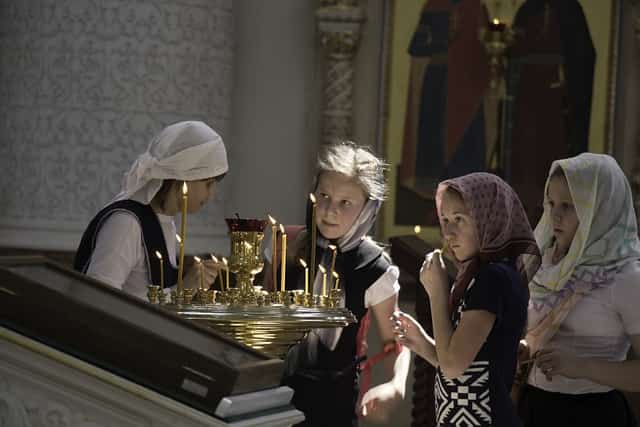 παιδια ανάβουν κεριά σε εκκλησία