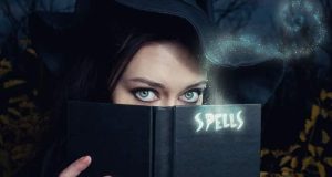 Η Ελισάβετ κρύβει το πρόσωπό της εκτό από τα μάτια της πίσω από ένα βιβλία με ξόρκια
