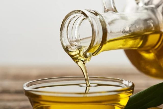 λάδι από το μπουκάλι ρίχνεται σε γυάλινο μπολ