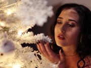 1 – 7 Ιανουαρίου: Ιδανική περίοδος Υλοποίησης Ευχών κοπέλα κοντά στο χριστουγεννιάτικο δέντρο