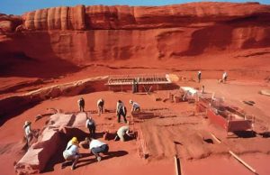 Ευρήματα σε Αυστραλία και Αίγυπτο που Ξαφνιάζουν ανασκαφή αρχαιολόγων με φόντο τον κόκκινο βράχο της Αυστραλίας