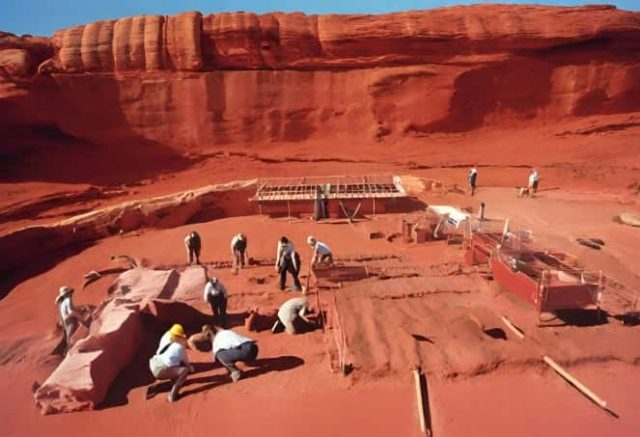 ανασκαφή αρχαιολόγων με φόντο τον κόκκινο βράχο της Αυστραλίας