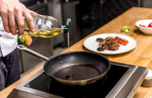 Τηγάνισμα: Ο τρόπος για να μην πιτσιλάει το λάδι παντού χέρι ρίχνει λάδι σε τηγάνι για τηγάνισμα