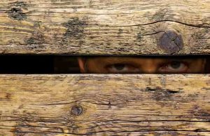 Αυτός Είναι ο Πανάρχαιος Εχθρός του Έλληνα ο Πανάρχαιος Εχθρός του Έλληνα που κοιτάζει μέσα από χαραμάδα. Φαίνονται μόνο τα μάτια.