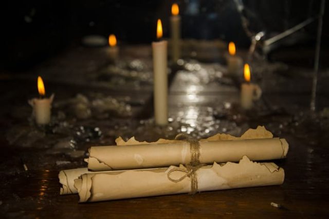 Μυστηριώδη αρχαία ειλητάρια, πάνω στο τραπέζι με κεριά