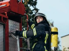 Πυροσβέστης Άναβε τη Σπίθα Ψυχικών Ικανοτήτων Γυναίκα Πυροσβέστης στο πίσω μέρος πυροσβεστικού οχήματος