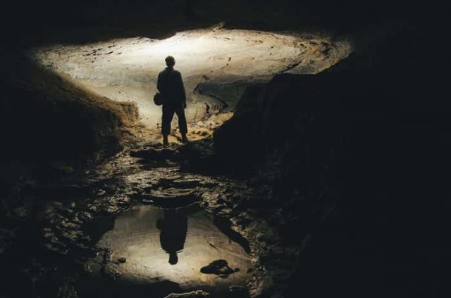 Άντρας σε μισοφωτισμένο σπήλαιο., θεωρητικά κάτω από τον φερόμενο ως ο Πρώτος Ναός του Ορφέα