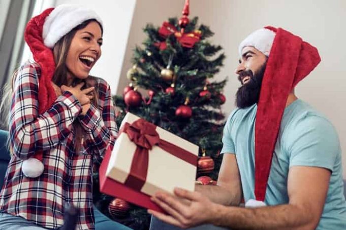 Πότε Γιορτάστηκαν Επίσημα τα Χριστούγεννα πρώτη φορά Νεαρός άνδρας δίνει στη φίλη του χριστουγεννιάτικο δώρο