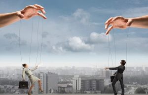 Ποιος Ελέγχει τον Κόσμο στον οποίο Ζούμε δύο χέρια κουκλοπαίκτες δύο ανθρώπων απαντά στο ερώτημα Ποιος Ελέγχει τον Κόσμο